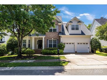 Charming two-story home featuring a brick facade, a two-car garage, and a beautifully landscaped front yard at 1458 Bedlington Nw Dr, Charlotte, NC 28269
