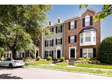A row of townhomes showcases a blend of brick and siding, complemented by lush landscaping and a nearby car at 15623 Sir Charles Pl, Charlotte, NC 28277