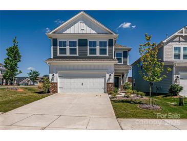 Frontal view of two-story house, featuring blue shutters, white trim, and two-car garage at 16042 River Tree Ln, Charlotte, NC 28278