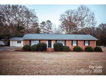 Charming brick ranch home with manicured bushes, dark shutters and a spacious front yard at 1708 Dogwood Ln, Lancaster, SC 29720