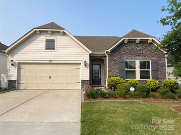 Charming single-story home featuring stone accents, a two-car garage, and a well-maintained front yard at 1825 Lotus Ln, Denver, NC 28037