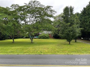 Expansive front yard featuring lush green lawn and mature trees, offering a serene and inviting curb appeal at 2009 Hickory Grove Rd, Gastonia, NC 28056