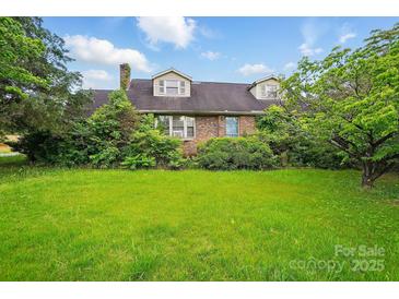 Traditional brick home with mature trees and an expansive green lawn, offering classic charm at 2505 Charlotte Hwy, Fort Mill, SC 29707