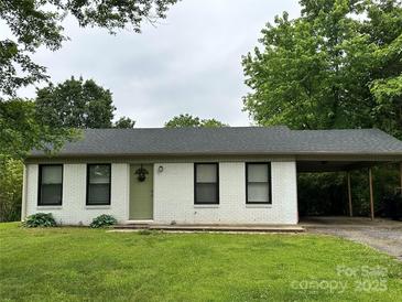 Charming single-story home featuring a carport, freshly painted white brick, and a well-maintained green lawn at 413 Picadilly Ln, Troutman, NC 28166