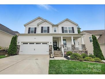 Charming two-story home featuring a welcoming front porch, attached two-car garage, and well-maintained landscaping at 4842 Durneigh Dr, Kannapolis, NC 28081