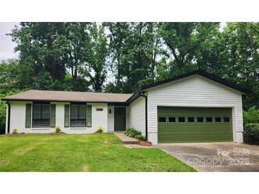Charming single-story home with a green garage door and well-manicured lawn at 7228 Rollingridge Dr, Charlotte, NC 28211