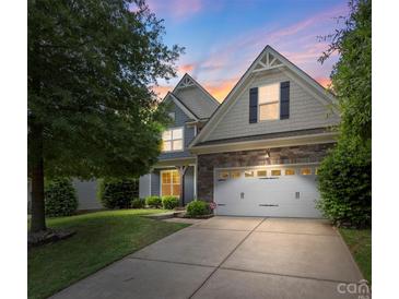 Charming home with a two-car garage, stone accents, and a well-maintained lawn at 9230 Loch Glen Way, Charlotte, NC 28278