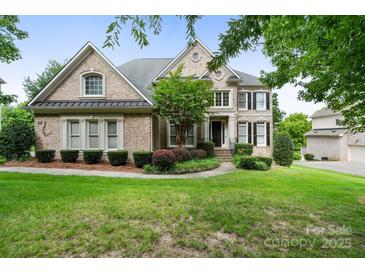 Charming brick home with manicured landscaping, mature trees, and a well-maintained lawn at 9433 Wallace Pond Dr, Huntersville, NC 28078