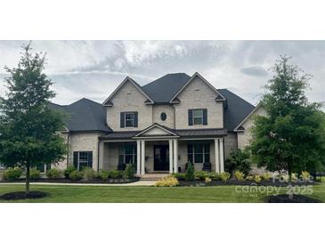 Stunning two-story brick home with manicured lawn and charming front porch at 1152 Grand Oak Dr, Waxhaw, NC 28173