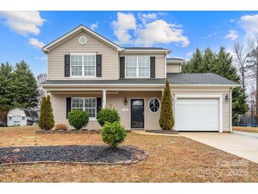 Charming two-story home featuring a manicured front yard and attached one car garage at 130 Valley Glen Dr, Troutman, NC 28166