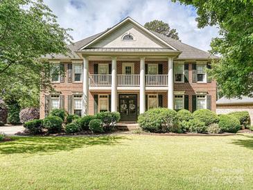 Elegant brick home with white columns, second story balcony, and manicured front lawn at 18419 Dembridge Dr, Davidson, NC 28036
