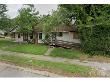 A charming one-story home with a front yard needing some TLC at 306 E Arch St, Lancaster, SC 29720