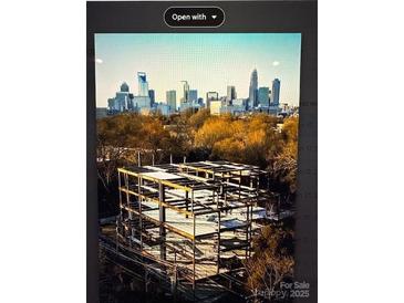 A building construction site with a skyline view showcases progress and urban development at 409 Queens Rd # 401, Charlotte, NC 28207