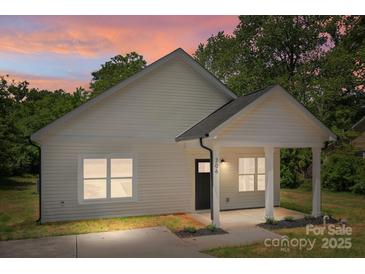 Charming home featuring a covered porch with white columns and beautiful sunset sky at 706 Live Oak St, Shelby, NC 28150