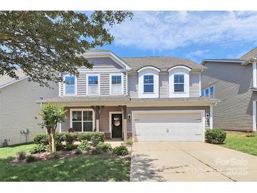 Charming two-story home featuring a well-manicured lawn and an attached two-car garage at 8916 Inverness Bay Rd, Charlotte, NC 28278