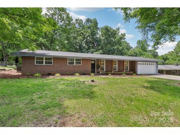 Charming single-story brick home with manicured lawn, mature trees, and attached two-car garage at 1192 Carolyn Dr # 9, Albemarle, NC 28001