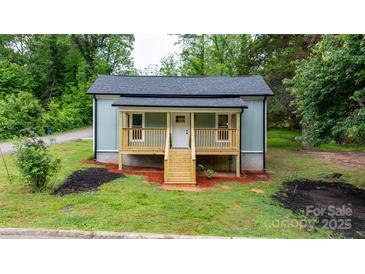 Charming cottage-style home featuring a cozy porch with wooden railing and fresh landscaping at 18 S Coulter Ave, Newton, NC 28658