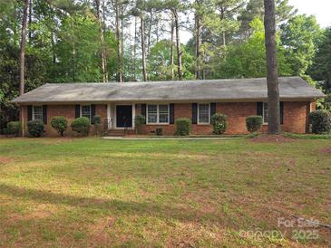 Charming brick ranch home with a well-manicured lawn and mature trees, offering great curb appeal at 3316 Mckee Rd, Charlotte, NC 28270