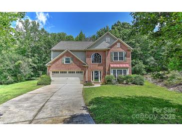 Charming two-story brick home with a well-manicured lawn and a two-car attached garage at 705 Moss Creek Dr, Matthews, NC 28105