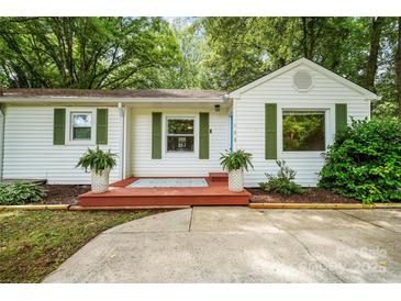 Charming single-story home featuring a well-manicured lawn and inviting curb appeal with a cozy front porch and lush greenery at 108 Greenwood Ave, Belmont, NC 28012
