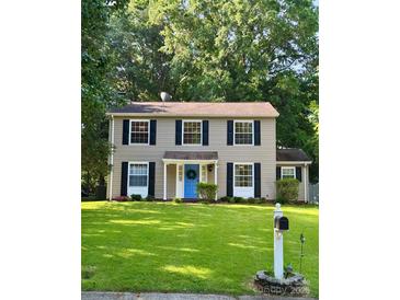 Charming two-story home featuring a blue front door and well-maintained lawn and traditional black shutters at 11718 Battery Pl, Charlotte, NC 28273