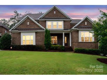 Charming brick home featuring a well-manicured lawn, and manicured landscaping at 13102 Indigo Run Ct, Charlotte, NC 28278