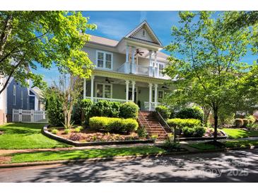 Inviting two-story home with covered porch, landscaped yard, and mature trees under a sunny sky at 15430 Waterfront Dr, Huntersville, NC 28078