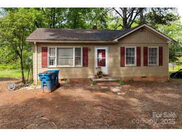 Charming tan single-story home with red shutters and front yard at 208 N School St, Mount Gilead, NC 27306