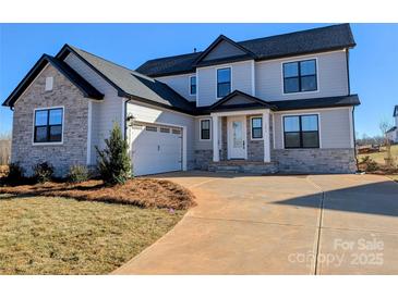 Charming two-story home with a combination of light gray siding and stone accents, complemented by a two-car garage at 2092 Fordhill St, Rock Hill, SC 29732