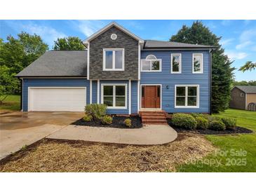 Charming two-story home with blue siding, stone accents, well-manicured landscaping, and an attached two-car garage at 2532 Steeplechase Rd, Gastonia, NC 28056