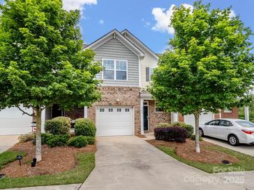 Charming townhome showcasing manicured landscaping, neutral brick, and a driveway leading to the attached garage at 3306 Yarmouth Ln, Gastonia, NC 28056