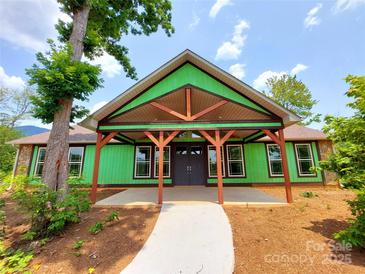 New construction home featuring a covered porch with timber beams and a stone accent wall at 401 Constant Ln, Charlotte, NC 28722