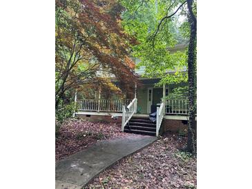 Charming home featuring a wide front porch and mature trees, creating a serene and inviting outdoor space at 8504 Knollwood Cir, Charlotte, NC 28213