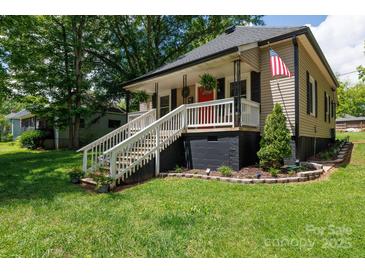 Charming home with a cozy front porch, white railing, a bright red door, and landscaped front yard at 118 Sunset Dr, Clover, SC 29710