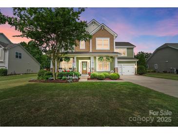 Charming two-story home with a well-manicured lawn, covered porch, and attached two-car garage at 132 Flora Vista Dr, Mooresville, NC 28117