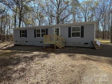 Charming single-story home with gray siding, black shutters, and a small wooden porch at 1380 St. Johns Church Rd, Concord, NC 28025