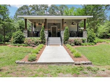 Charming single-story home featuring a welcoming front porch with stone accents and well-manicured landscaping at 1737 Hwy 109 N Hwy, Troy, NC 27371