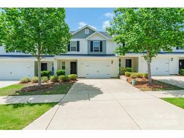 Exterior view of a townhouse with a driveway and lawn and large trees in front of each unit at 2009 Talbert Ct, Charlotte, NC 28214