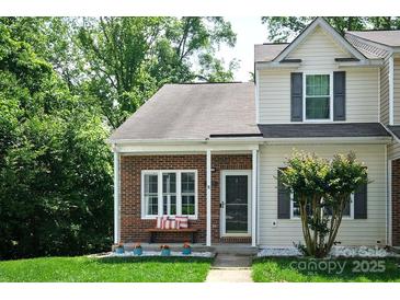 Charming townhouse with brick facade, covered entry, lovely landscaping, and inviting curb appeal at 327 Wilkes Place Dr, Fort Mill, SC 29715