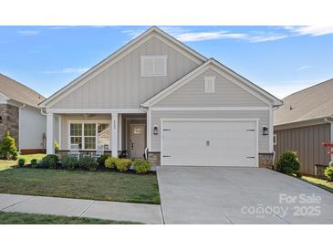 Charming single-Gathering home featuring a two-car garage and a well-manicured lawn with decorative shrubs at 4532 Stellata Loop, Sherrills Ford, NC 28673