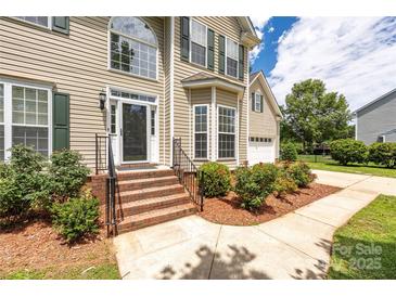 Charming home featuring a welcoming front entrance with beautiful landscaping and brick steps at 6504 Sybil Ct, Indian Trail, NC 28079