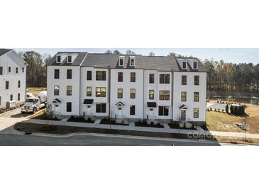 Modern townhouse exteriors with sleek, white facade and landscaping for a contemporary look at 7130 Westrow Ave # 37 End, Charlotte, NC 27278