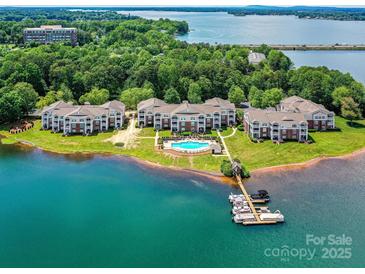 Stunning aerial view of waterfront condos, a community pool, boat docks, and the beautiful Lake Norman at 930 Jetton St, Davidson, NC 28036