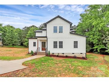 Charming new construction farmhouse with board and batten siding, lush landscaping, and inviting entry at 1011 Sandy Ct, Gastonia, NC 28056