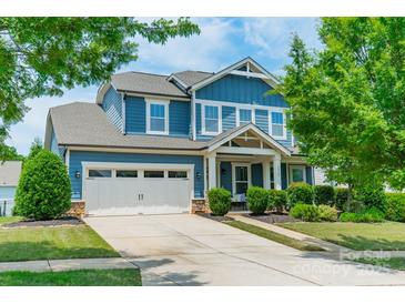 Charming two-story home with a blue exterior, two-car garage, and well-manicured landscaping at 12107 Grey Partridge Dr, Charlotte, NC 28278