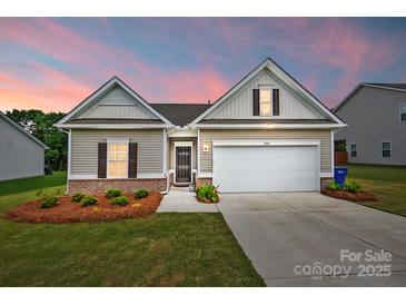 Charming single-Gathering home featuring a two-car garage, manicured lawn, and beautiful landscaping at twilight at 2928 Parkwest Dr, Albemarle, NC 28001