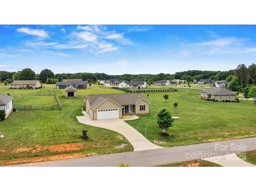 Charming home with a well-manicured lawn in a quiet neighborhood, complemented by a spacious driveway and attached garage at 3645 Kimber Ln, Sherrills Ford, NC 28673
