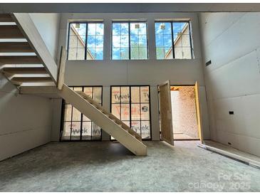 View of the staircase with large windows providing natural light to the open space at 5427 Addison Dr, Charlotte, NC 28211