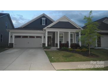Charming home featuring a well-maintained front yard, covered porch, and a two-car attached garage at 813 Latrobe Dr # 365, Iron Station, NC 28080