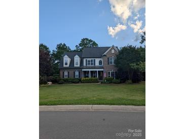 Charming two-story brick home with a well-manicured lawn and mature trees at 9000 Petunia Ct, Gastonia, NC 28056